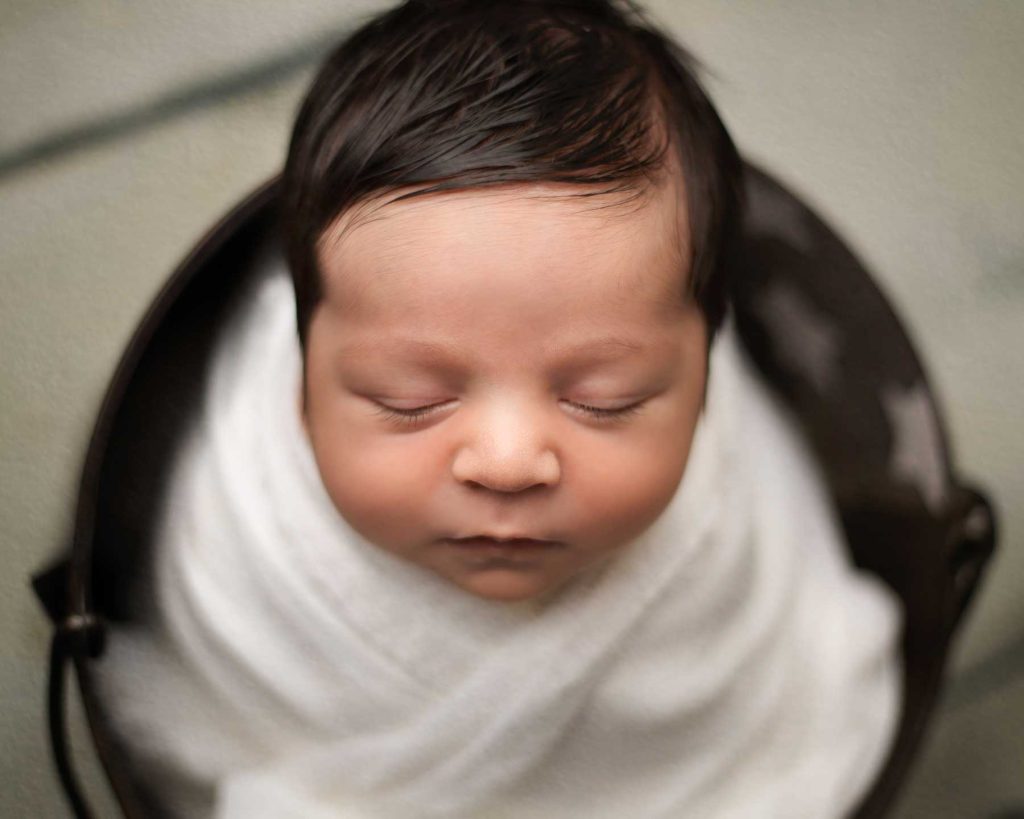 Close up of newborn wrapped in a basket