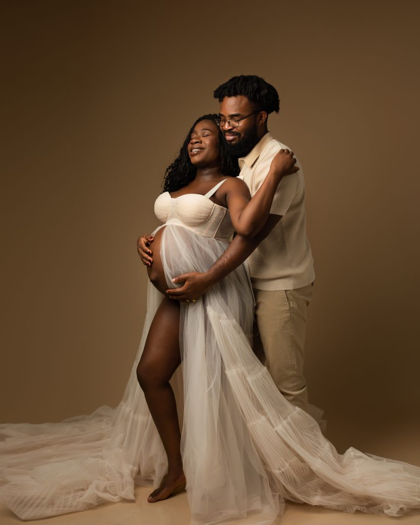 Couple Maternity Photography both in white against an earth toned background