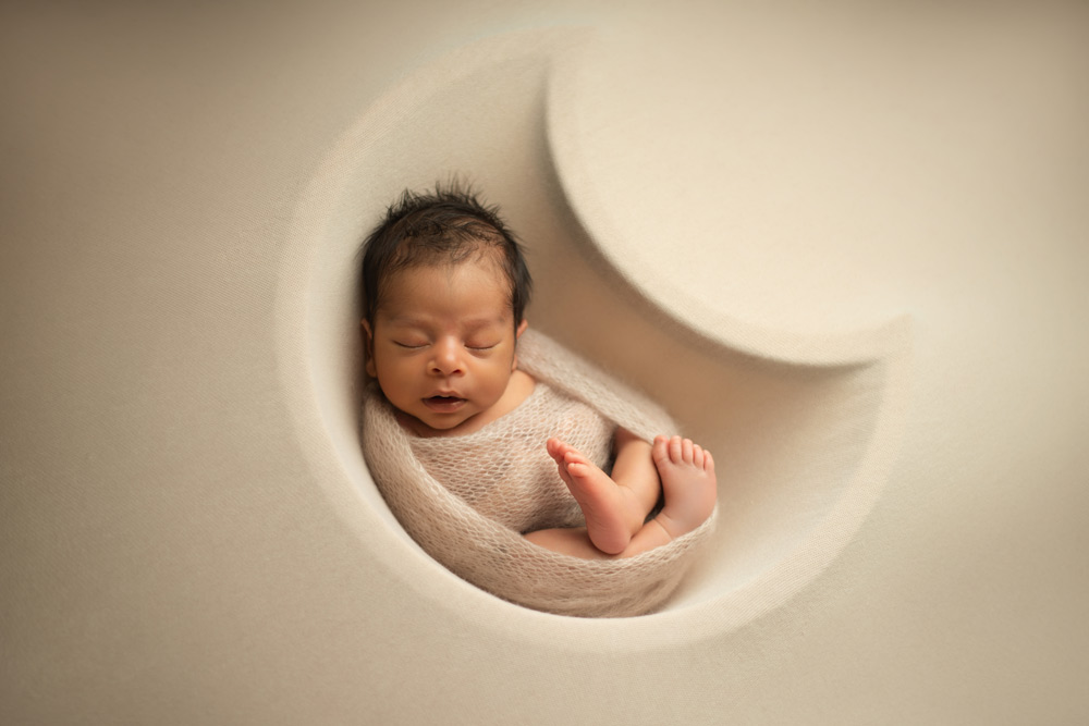 Newborn baby boy in a moon prop