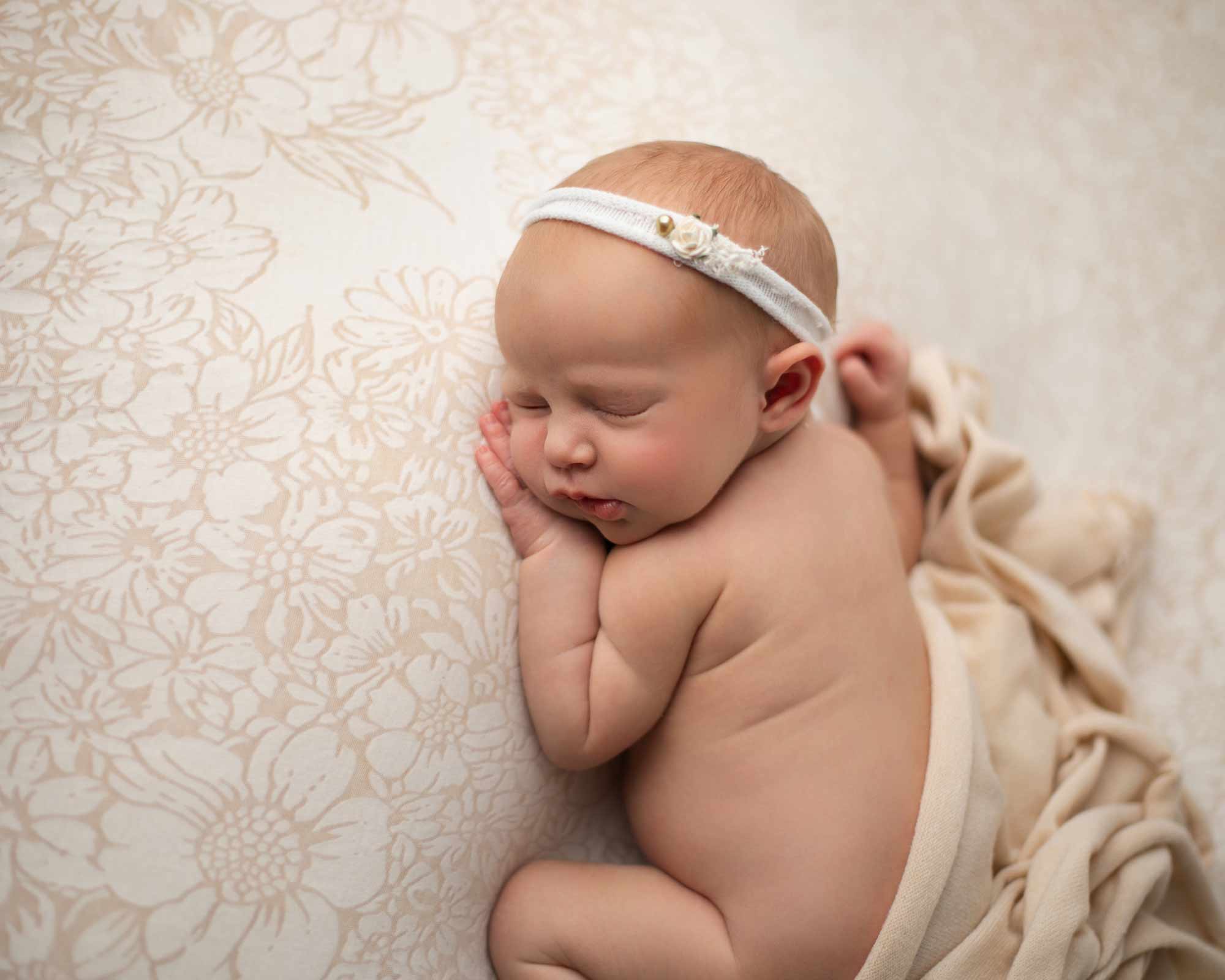Newborn photoshoot featuring a baby girl in neutral