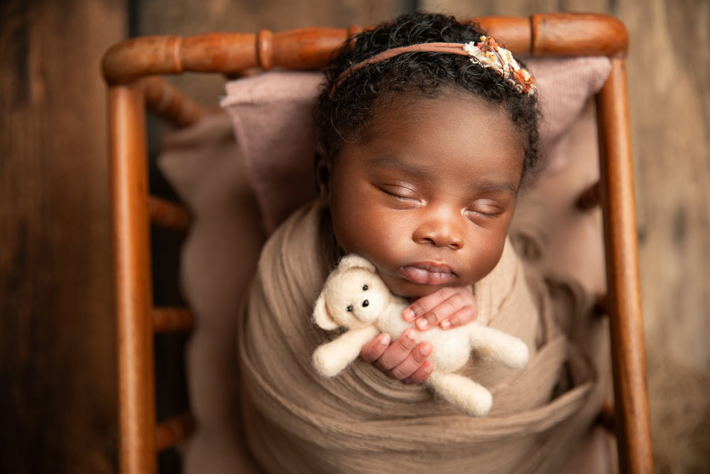 Newborn photoshoot with baby holding a teddy bear